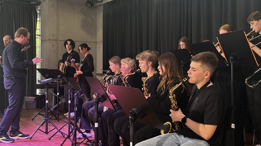 Schülerinnen und Schüler mit Musikinstrumenten auf der Bühne