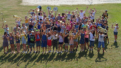 100 junge Musikerinnen und Musiker bilden eine XXL-Formation und sorgen für reichlich frischen Wind in der Aula.