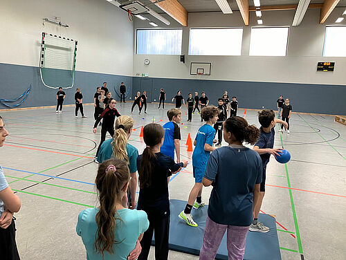 Schülerinnen und Schüler spielen Kegelbrennball