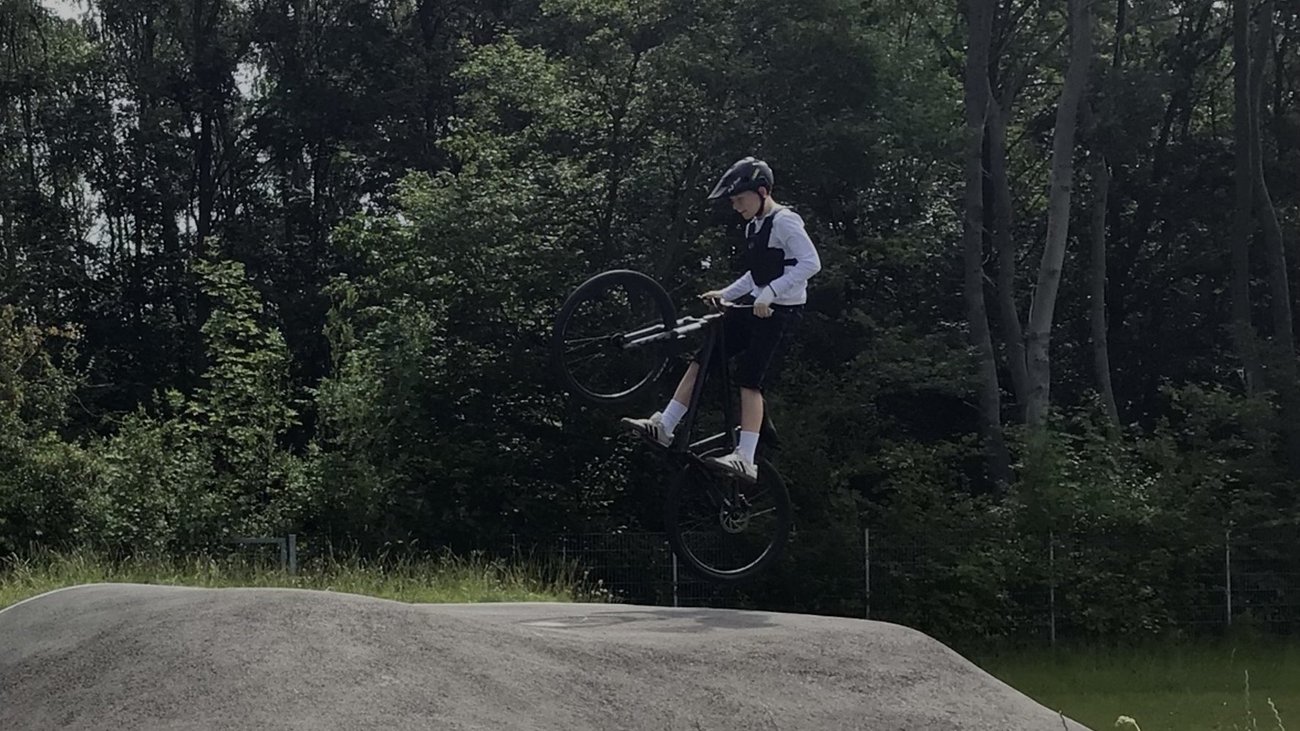Ein Schüler springt mit einem Mountainbike.