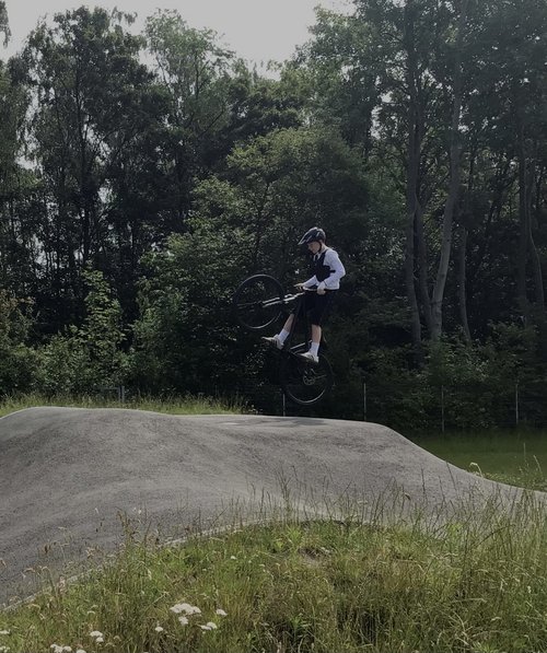 Ein Schüler springt mit einem Mountainbike.