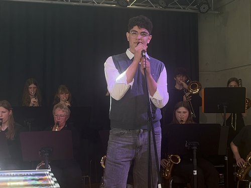 Schülerinnen und Schüler mit Musikinstrumenten auf der Bühne