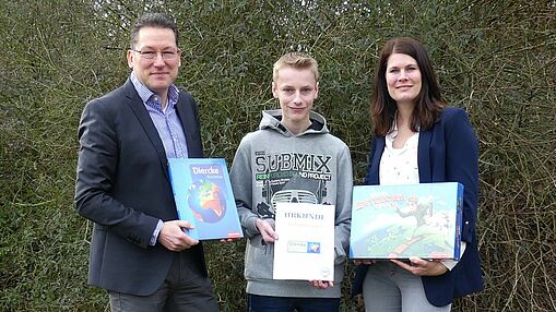 Schulleiter Robert Baberske und Erdkunde-Lehrerin Johanna Lameyer gratulieren Sven-Ole Gülke zu seinem Erfolg.