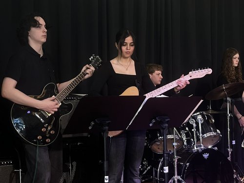 Schülerinnen und Schüler mit Musikinstrumenten auf der Bühne