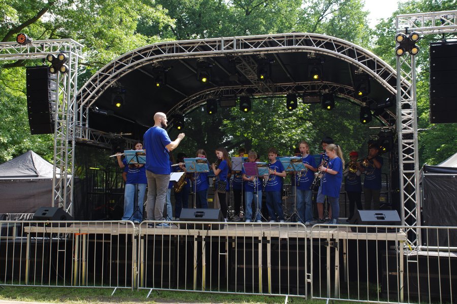 Schülerinnen und Schüler der Bläserklasse spielen auf der Bühne.